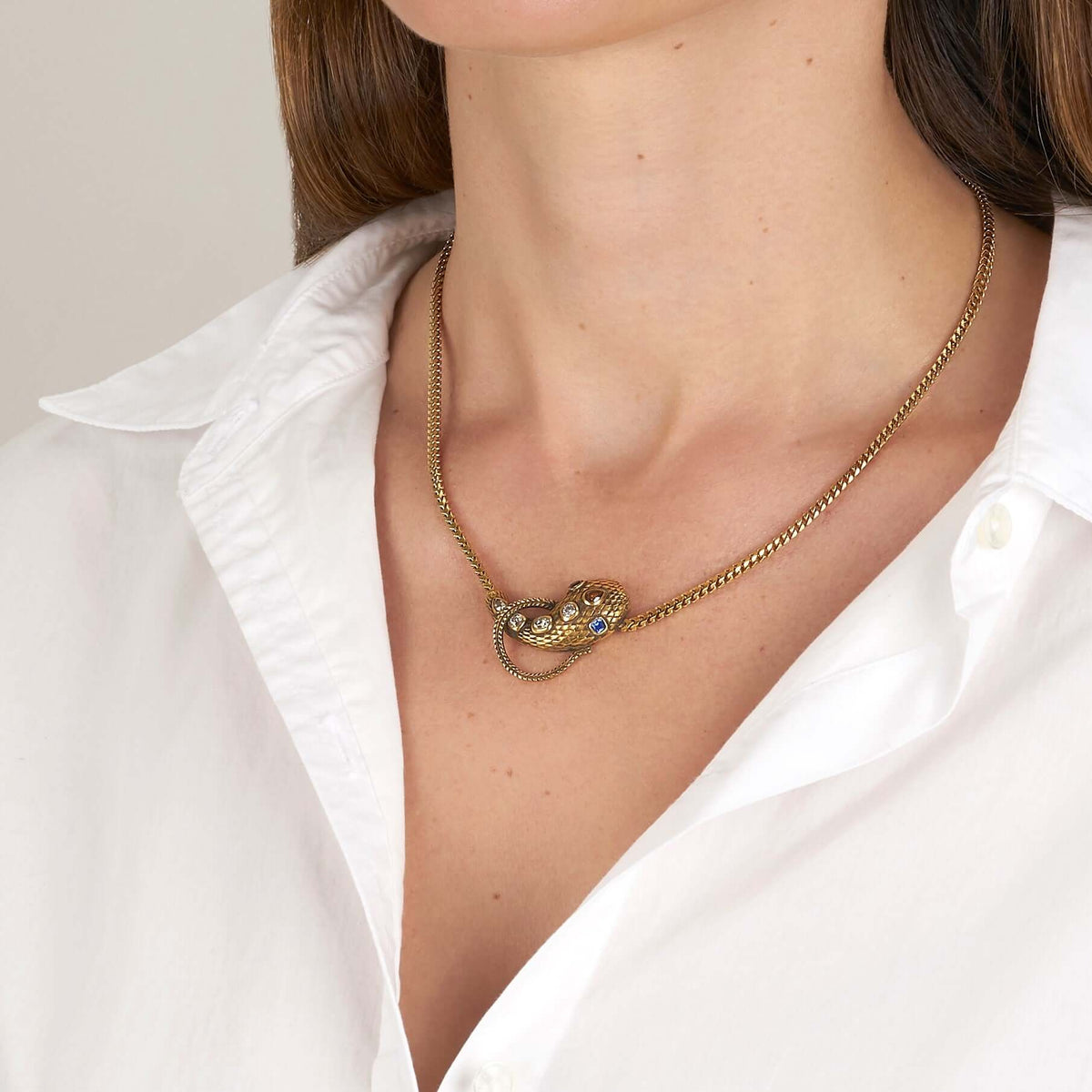 SINGLE STONE ALEXANDRIA SERPENT NECKLACE featuring 0.86ctw antique old mine, antique cushion, and pear cut diamonds featuring 0.44ctw cushion cut blue sapphire accent stones set on a handcrafted, oxidized 18K yellow gold snake pendant. Includes18K yellow