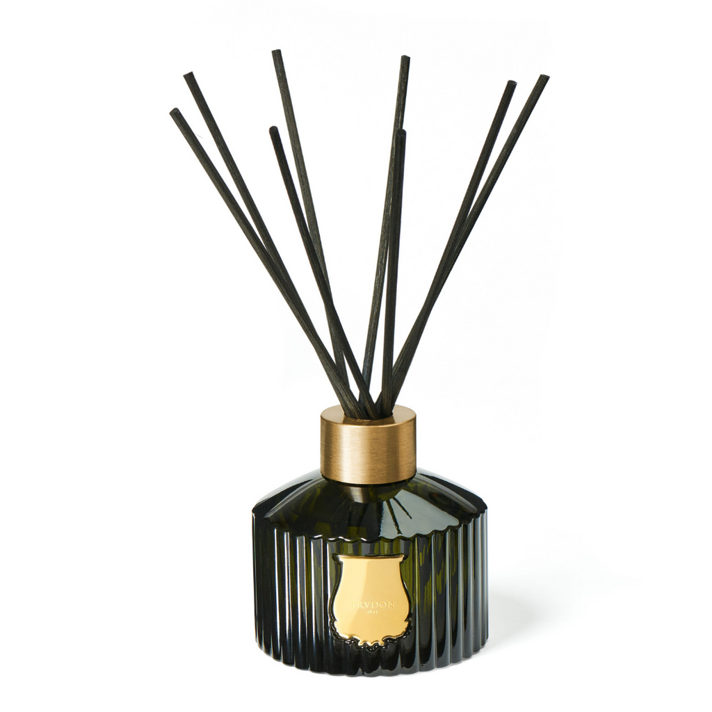 LE DIFFUSEUR, Shaped out of the same emblematic Trudon-green glass, the 350ml fluted container is adorned with a gold emblem. Handcrafted in the same glass manufacture as the candles, the Diffuser is topped with a 100% recyclable aluminum ring. Through it, you place 8 natural, black rattan sticks. 
The diffuser allows a 3 to 4-month long, passive diffusion. 
350ml 
, Fragrance, Trudon