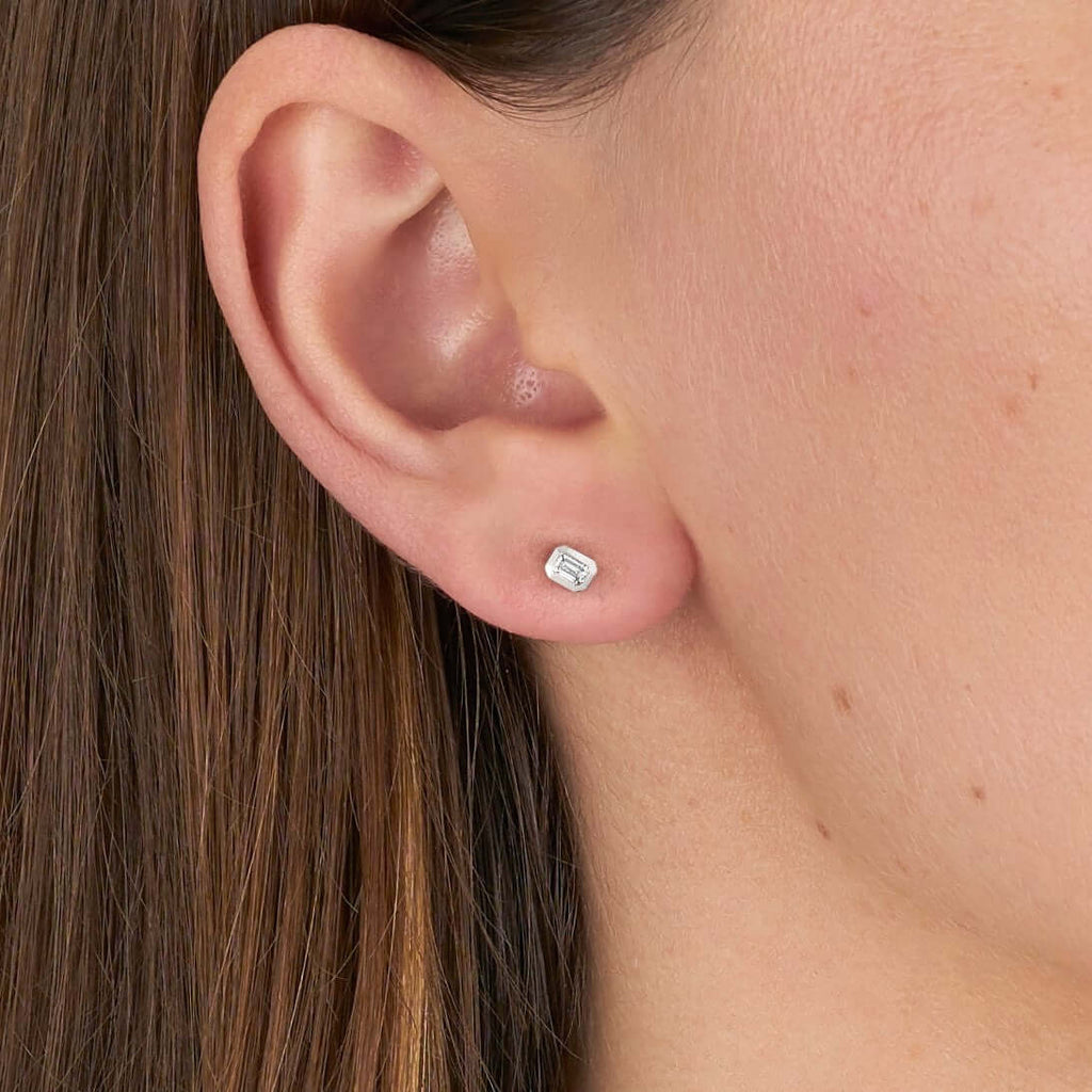 SINGLE STONE SIERRA STUDS | Earrings featuring Approximately 0.18ctw G-I/VS emerald cut diamonds bezel set in handcrafted stud earrings.