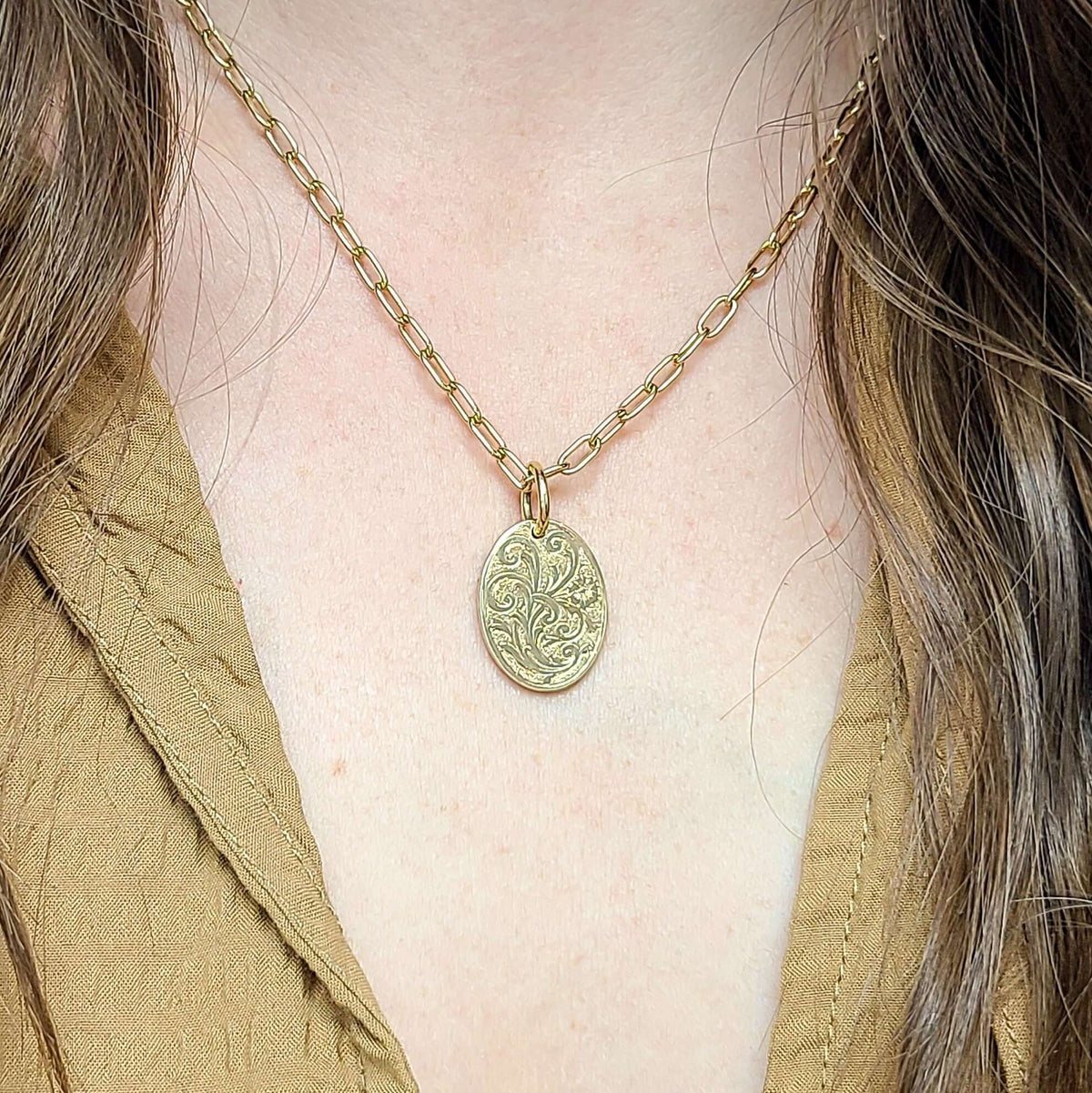 SINGLE STONE 20mm FLORAL ENGRAVED OVAL PENDANT PENDANT featuring Handcrafted 20mm floral engraved oval shaped pendant in 18K yellow gold. Price does not include chain.