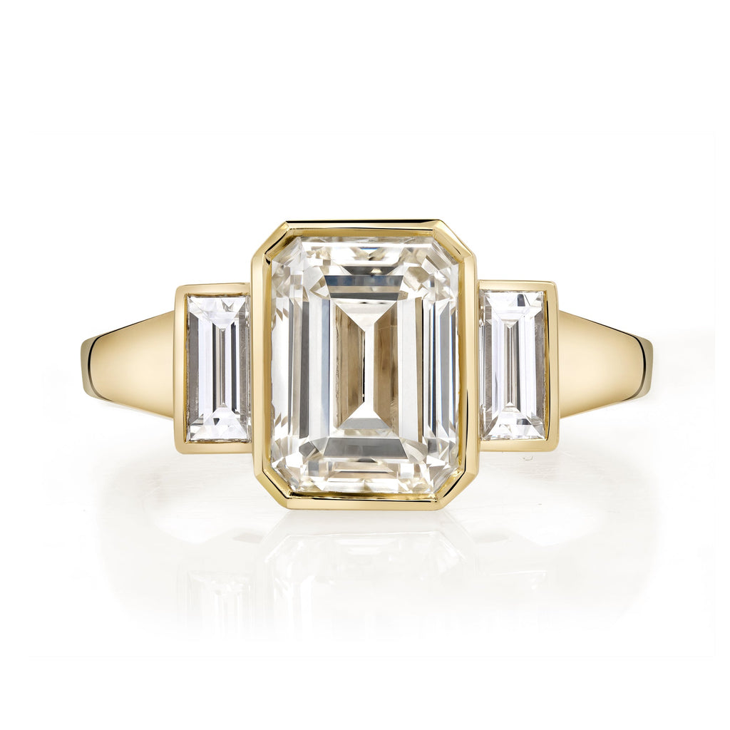SINGLE STONE AMELIA RING featuring 2.22ct N/VVSI GIA certified Emerald cut diamond with 0.37ctw baguette cut accent diamonds bezel set in a handcrafted 18K yellow gold mounting.