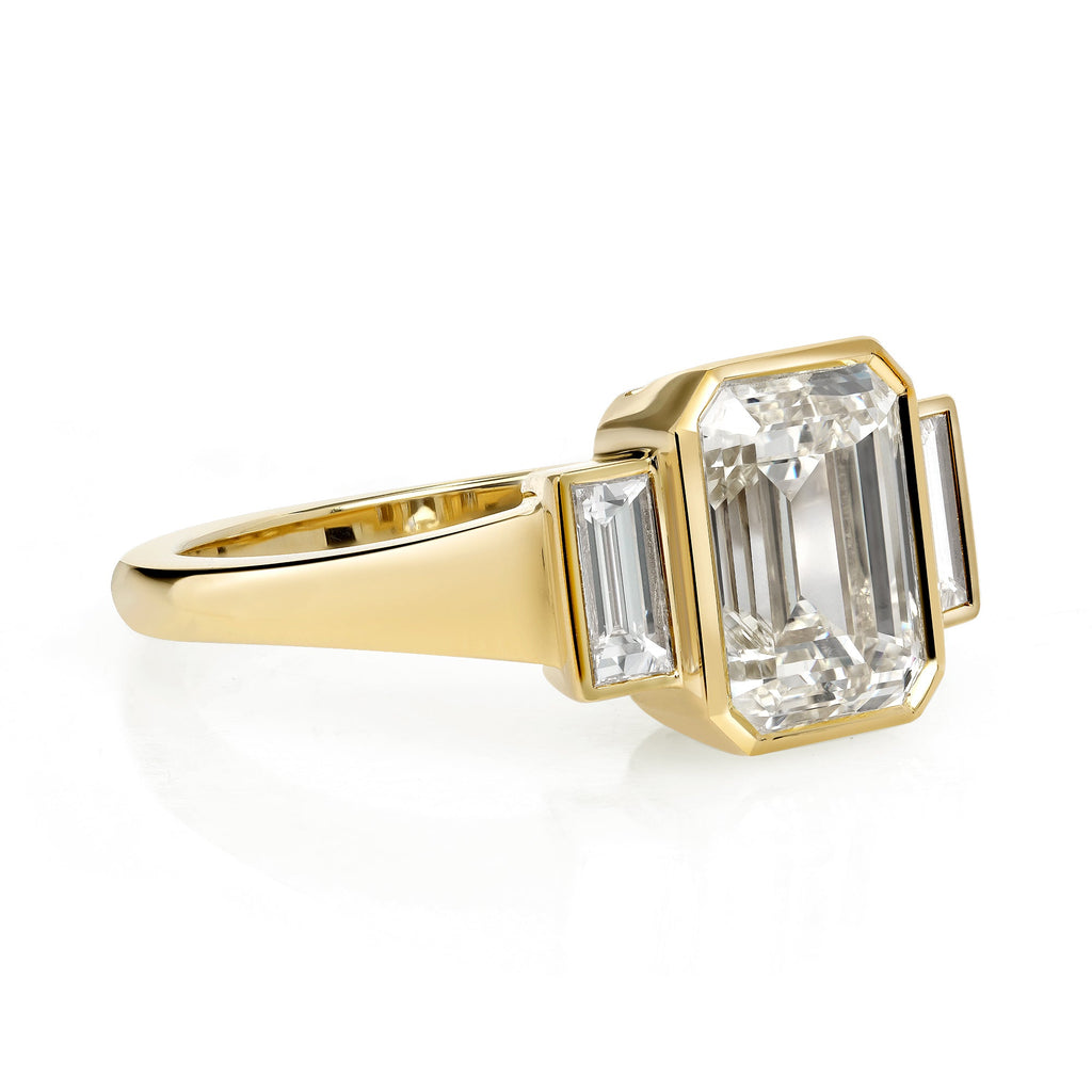 SINGLE STONE AMELIA RING featuring 2.22ct N/VVSI GIA certified Emerald cut diamond with 0.37ctw baguette cut accent diamonds bezel set in a handcrafted 18K yellow gold mounting.