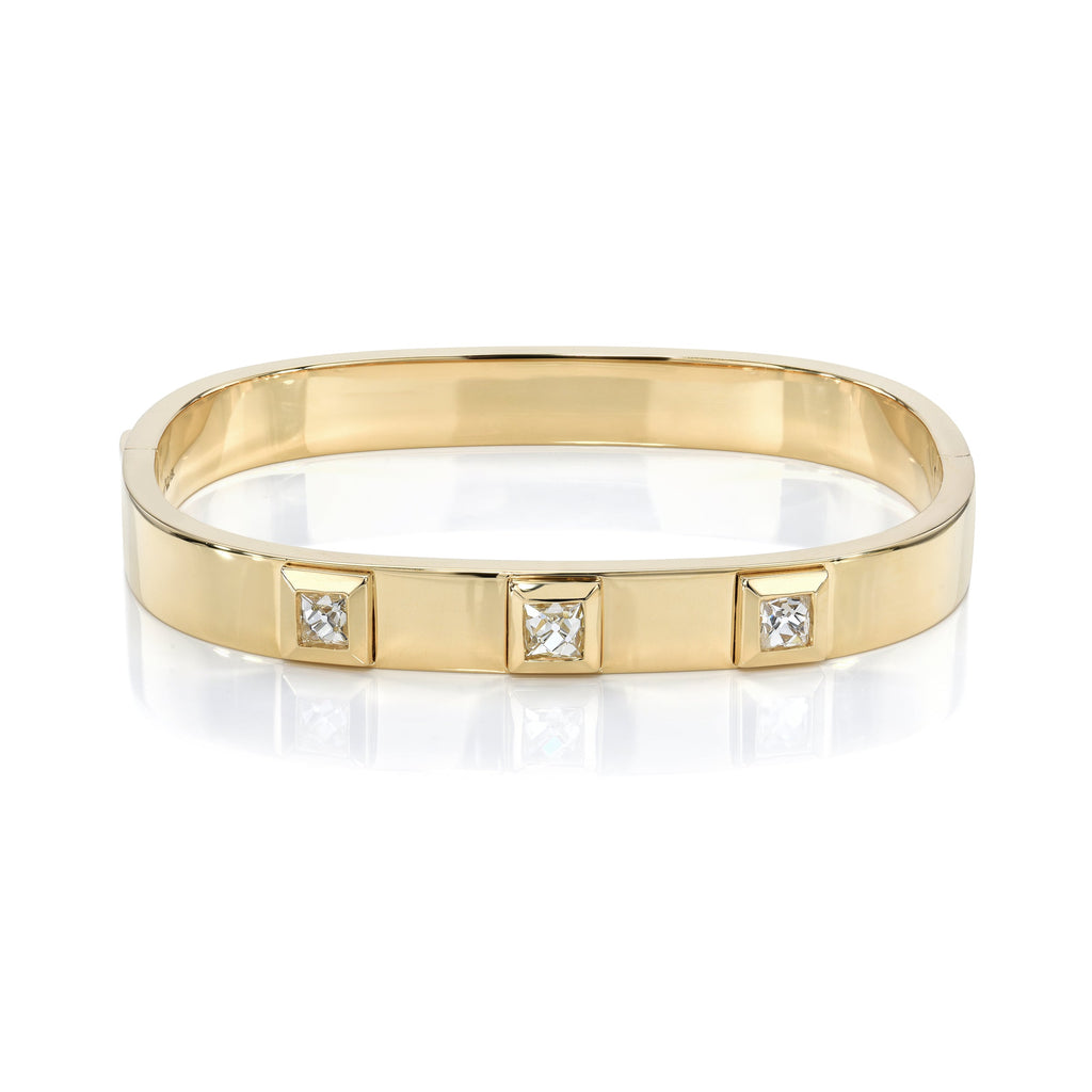 SINGLE STONE KARINA BANGLE featuring Approximately 1.35ctw H-I/VS French cut diamonds bezel set in a handcrafted 18K yellow gold bangle bracelet.